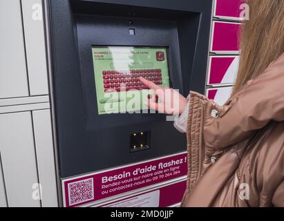 Loriol sur Drome, Frankreich - 14. Januar 2023: Abholung eines Pakets aus einem Mondial`Relay-Schließfach durch eine junge Frau. Schließfächer Mondial Relay. Pickup-Box. Stockfoto